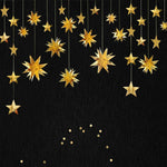 Pinkblume gold party decorations star garland front view hanging from a white ceiling.