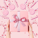 Individually wrapped pink candy buffet lollipops arranged neatly for a baby shower dessert table display.