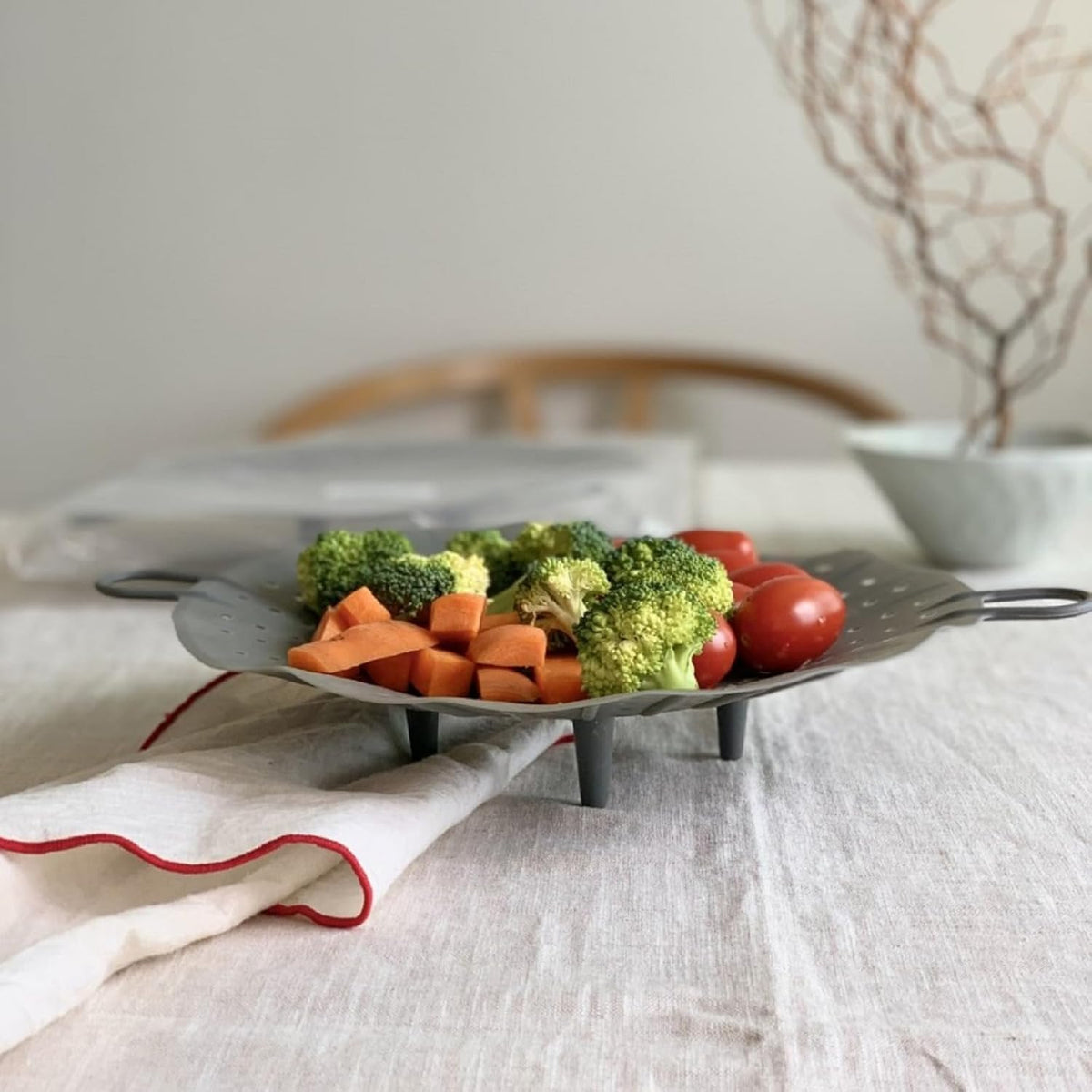 Steamer basket demonstrating flexible width adjustment