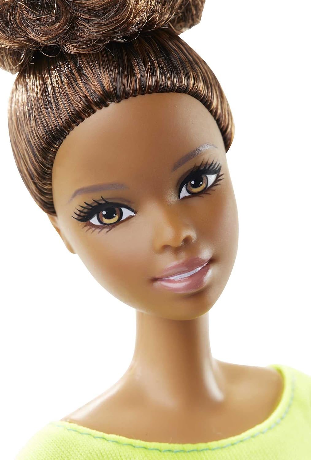 Close-up portrait of Barbie doll with brown hair and modern top.