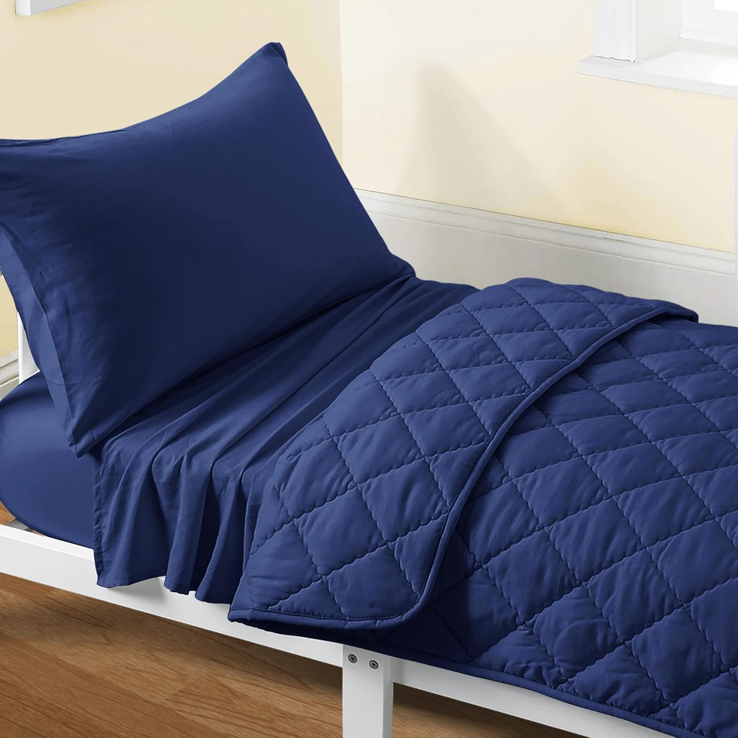 FLXXIE 4 piece toddler bedding set front view showcasing the solid navy blue quilted comforter.