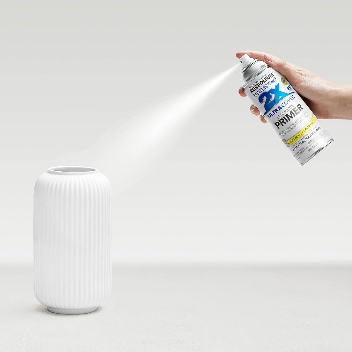 Painted metal object showing the smooth matte finish of the white primer