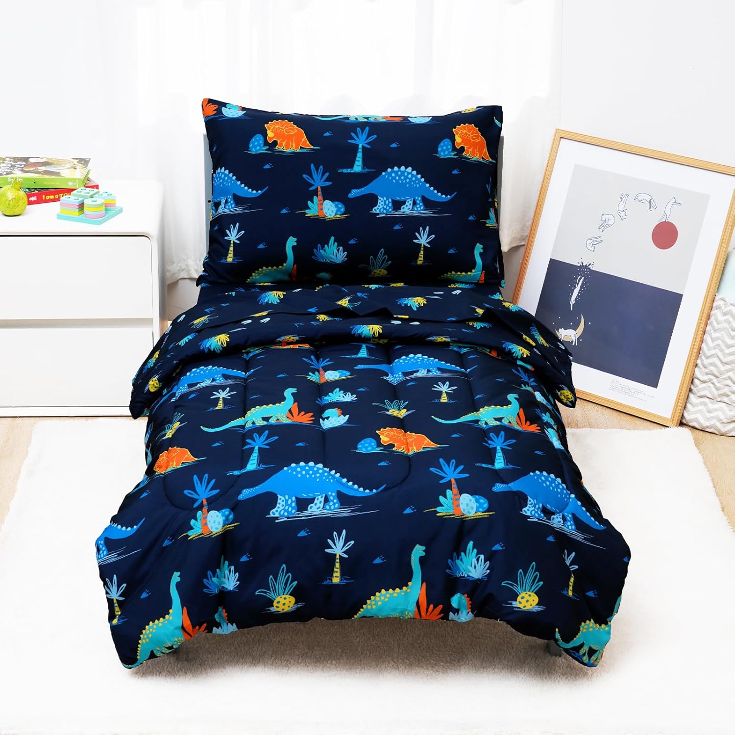 David's Kids 4 piece toddler bedding set front view showcasing the navy dinosaur pattern comforter and pillowcase.