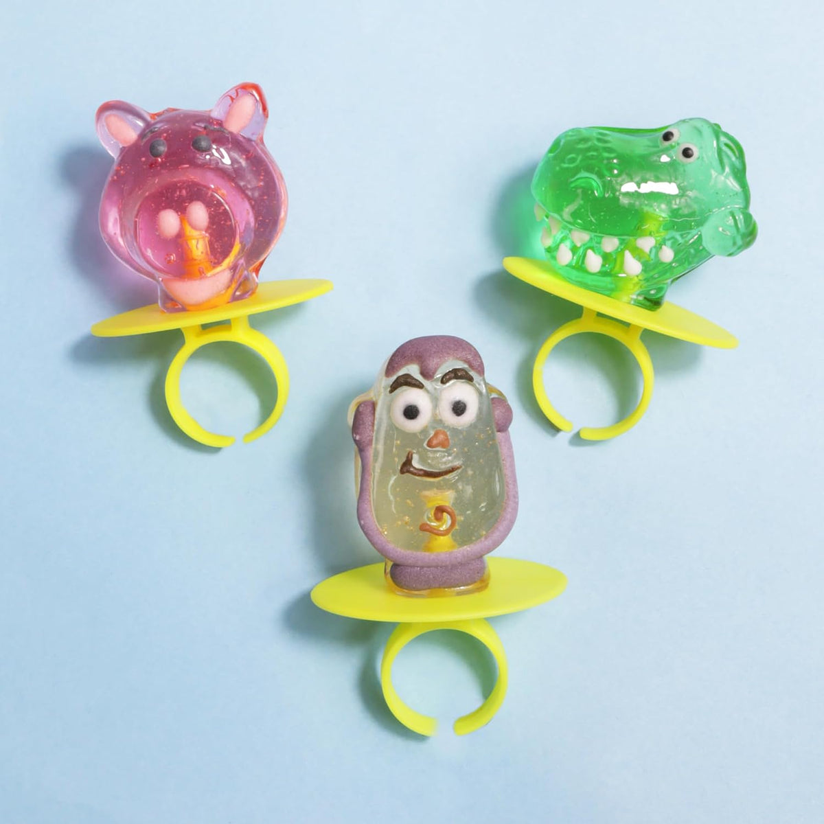 Toy Story themed birthday party favors arranged on a dessert table as cupcake toppers.