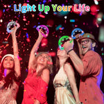 Group of people enjoying a concert with lighted musical tambourines in the dark