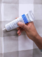 Roman 3 ounce wallpaper adhesive packaging and label display