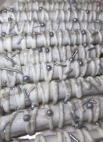 Close up of gourmet white chocolate pretzel rods with silver decorations