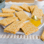 Top down shot of premium plant based sesame seed snack bars highlighting their crispy texture.