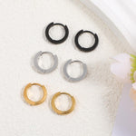 Detailed view of the gold huggie hoop earring showing the secure click-top closure.