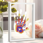 CHERRY CHEERS Family Handprint Kit front view showing the white wooden frame with layered transparent sheets and colorful prints.
