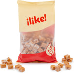 A scattered pile of unwrapped rich golden brown caramel squares showing their uniform cube shape.