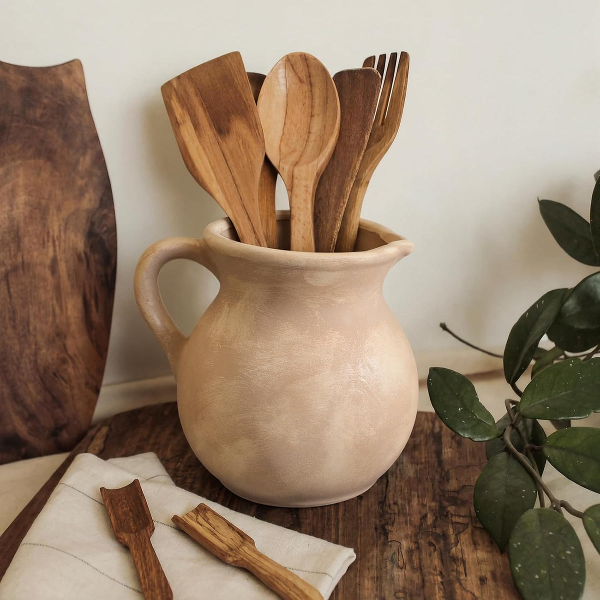 Potchen antique beige crock styled with spatulas and spoons on a kitchen counter