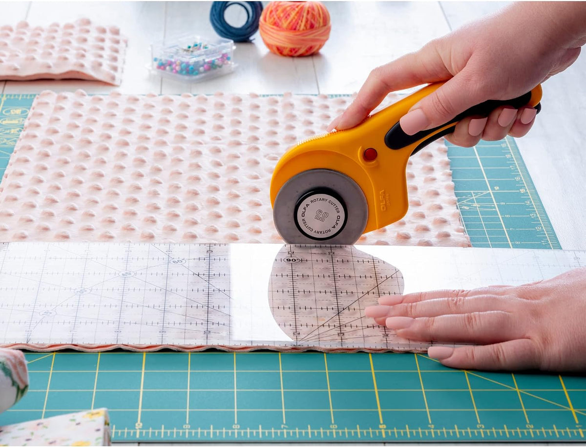 Olfa heavy-duty rotary cutter in use on fabric layers