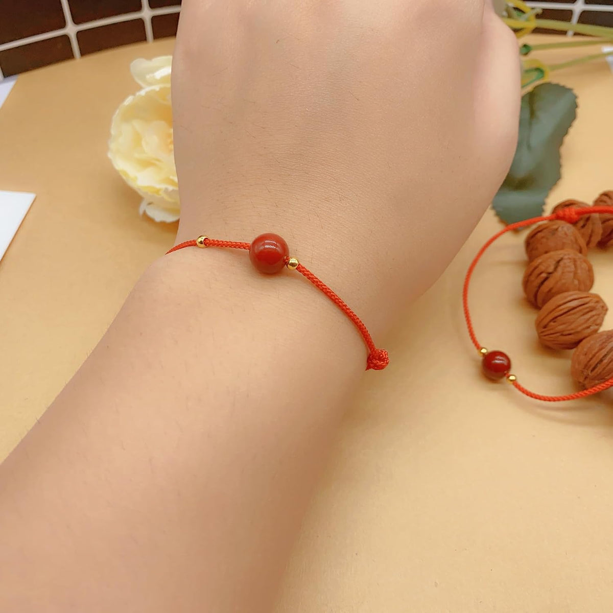 Close up of polished cinnabar bead on red braided cord