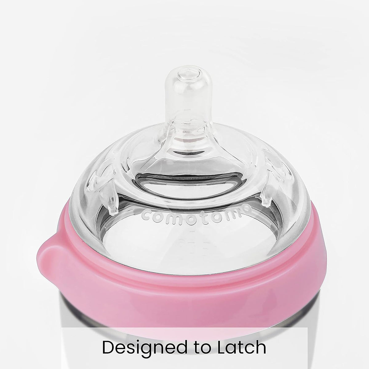 Comotomo pink silicone baby bottle showing soft squeezable body