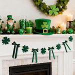 CRAFLOX St Patricks Day felt shamrock bow garland front view hanging on a white fireplace mantel