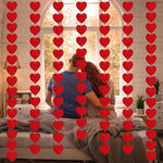 AinDen Valentines Day Decorations front view of ninety six pieces red felt heart garland hanging over a fireplace mantle