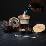 Wooden smoker infuser cap sitting on top of a whiskey glass with rising smoke