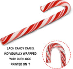 Gift Boutique Christmas candy canes used as edible decorations hanging on a holiday tree branch.