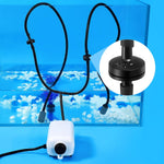 Black aquarium tubing installed in a freshwater fish tank blending into the dark background.