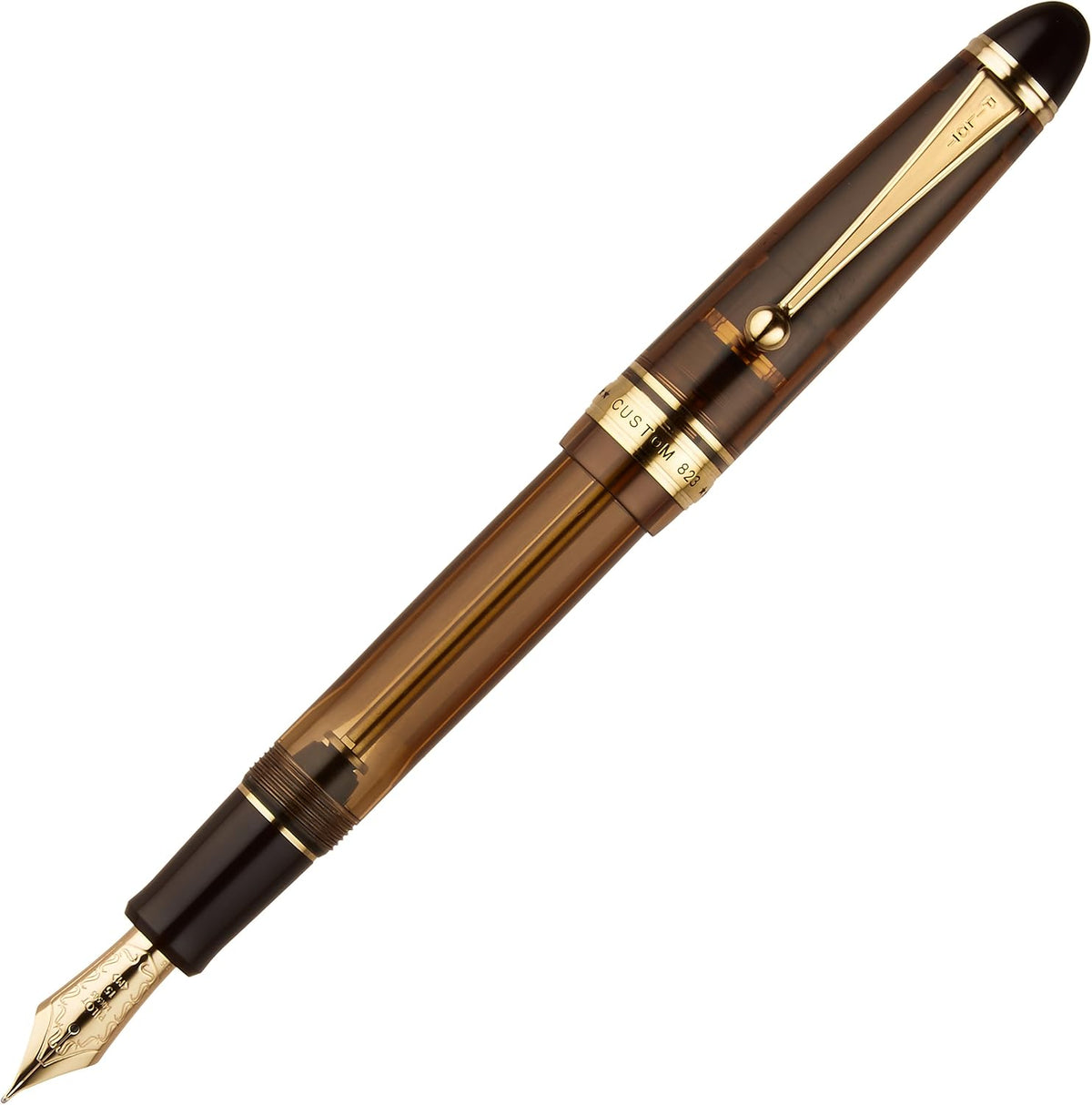 Pilot Custom 823 fountain pen front view showcasing transparent brown finish and gold trim.
