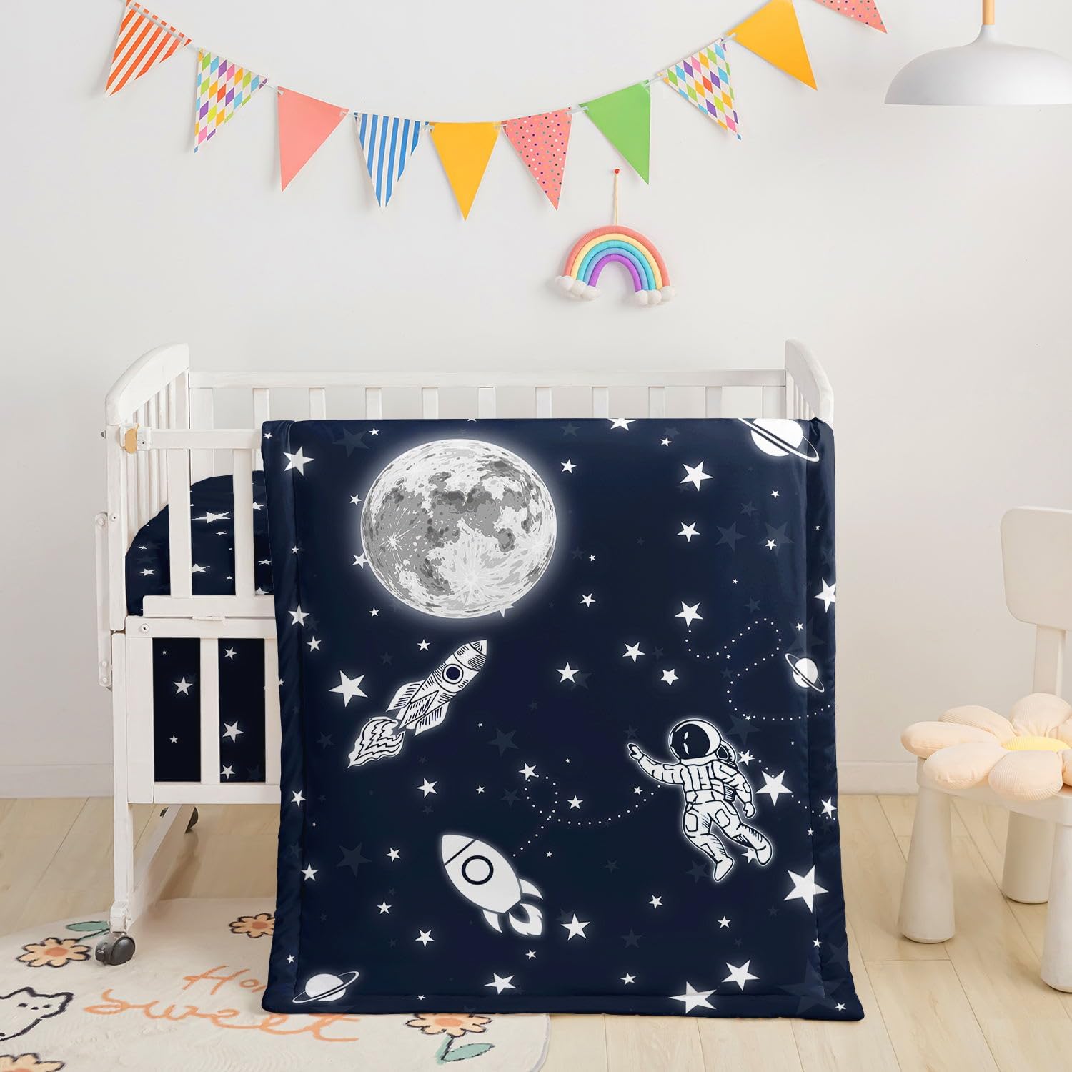 Datura Home Crib Bedding Set front view featuring a black rocket and astronaut printed quilted comforter.