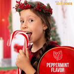 Oversized Christmas peppermint candy canes being placed in a holiday gift basket