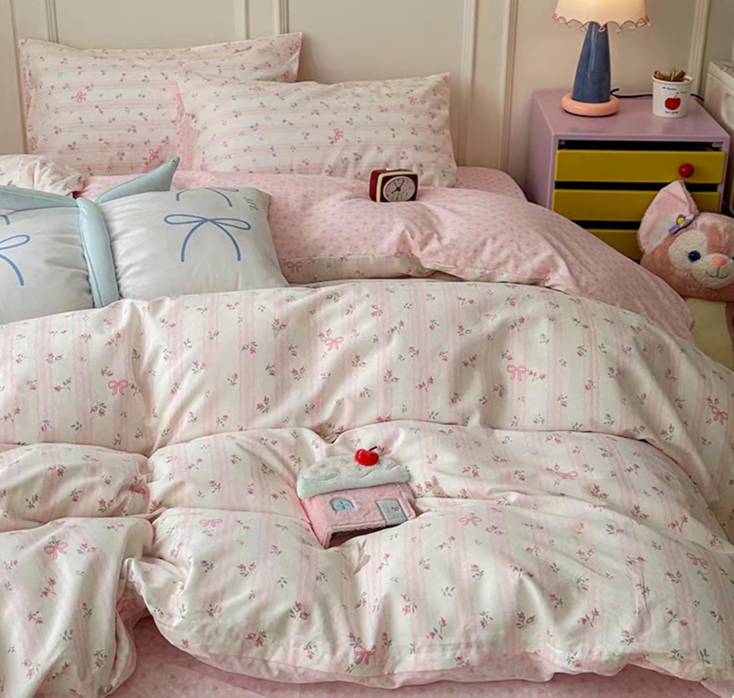 Sedefen floral pink striped duvet cover set spread out on a full size bed in a bright bedroom view.