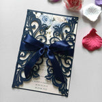 Generic laser cut wedding invitations cards front view displaying intricate navy blue filigree patterns and tied satin ribbon.