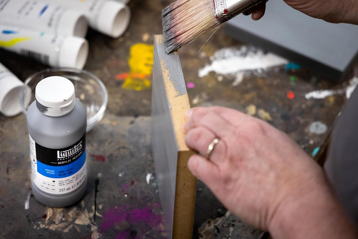 Artist applying clear primer with flat brush