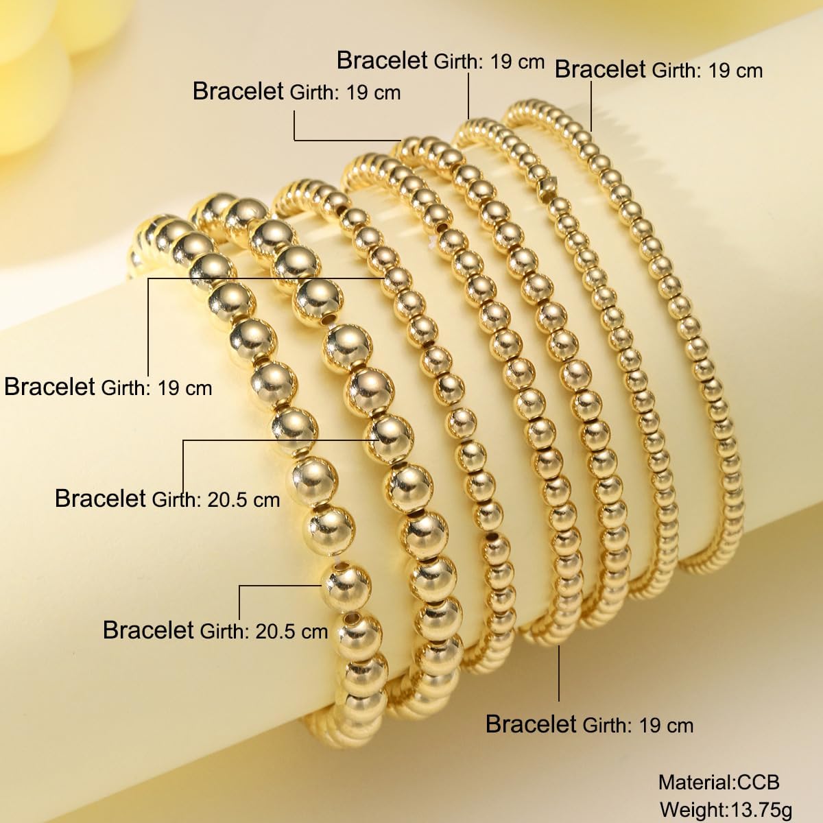 Model wrist wearing the complete 7-piece multi-strand gold stretch bracelet set.