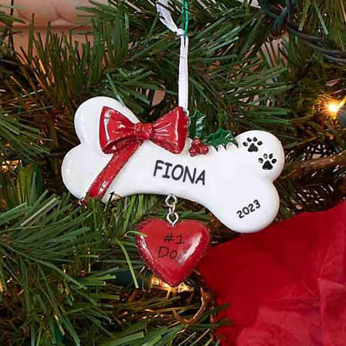Dibsies custom dog bone ornament showing hand-painted red bow