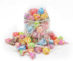 Mystery flavor Dum Dums lollipop next to cherry and blue raspberry flavors