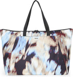 TUMI travel tote lifestyle view being carried by traveler