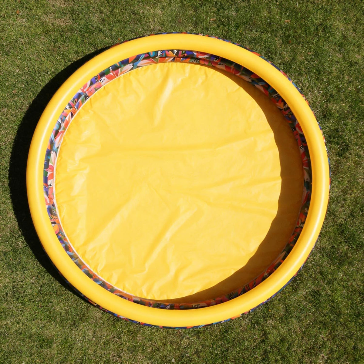 CHICLIST kids inflatable swimming pool front view showing the three jungle themed rings inflated in a backyard garden setting.