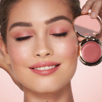 Close up of Charlotte Tilbury Pillow Talk cream blush swatch on hand