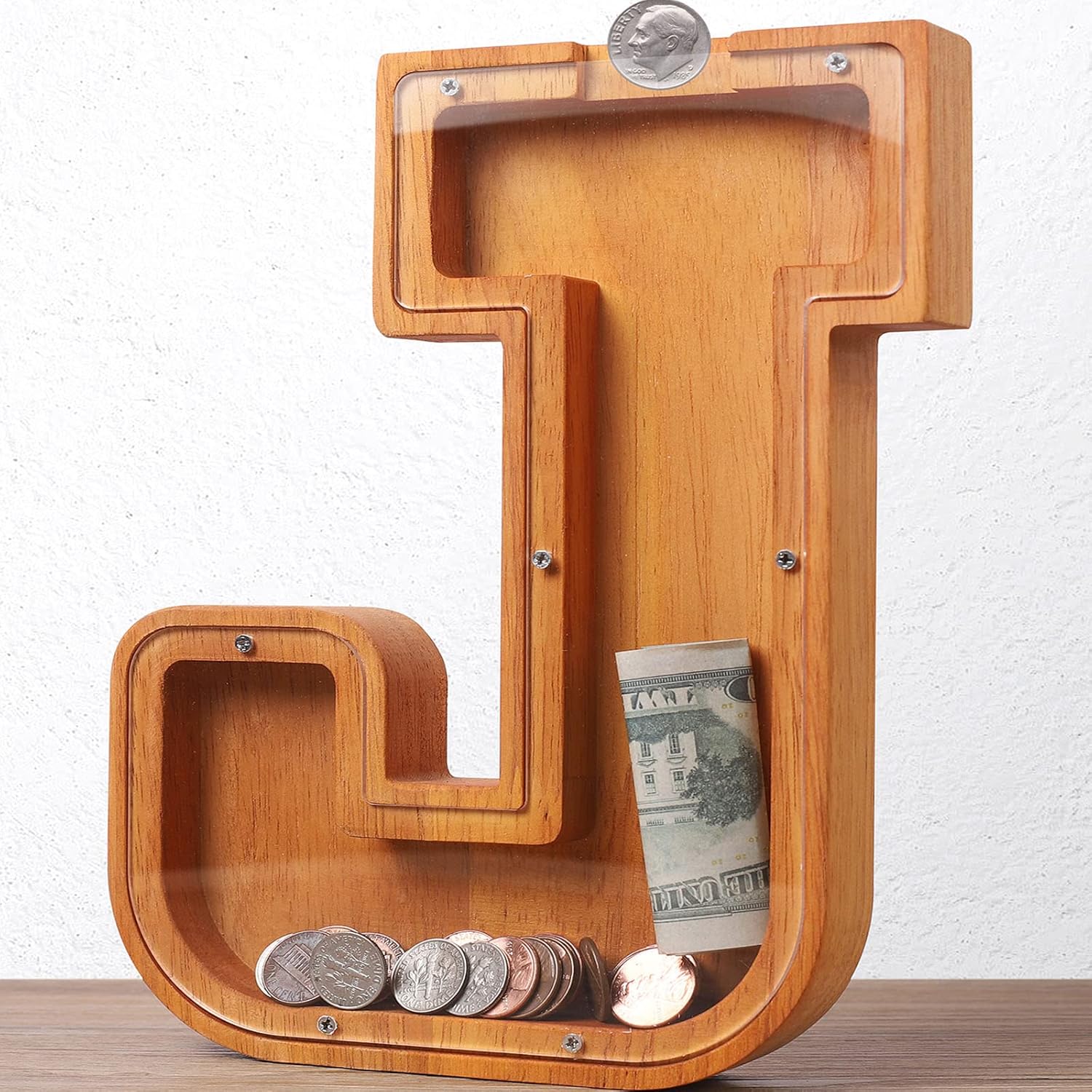 HODNSZRIT wooden letter J piggy bank front view showing transparent panel and coin slot.