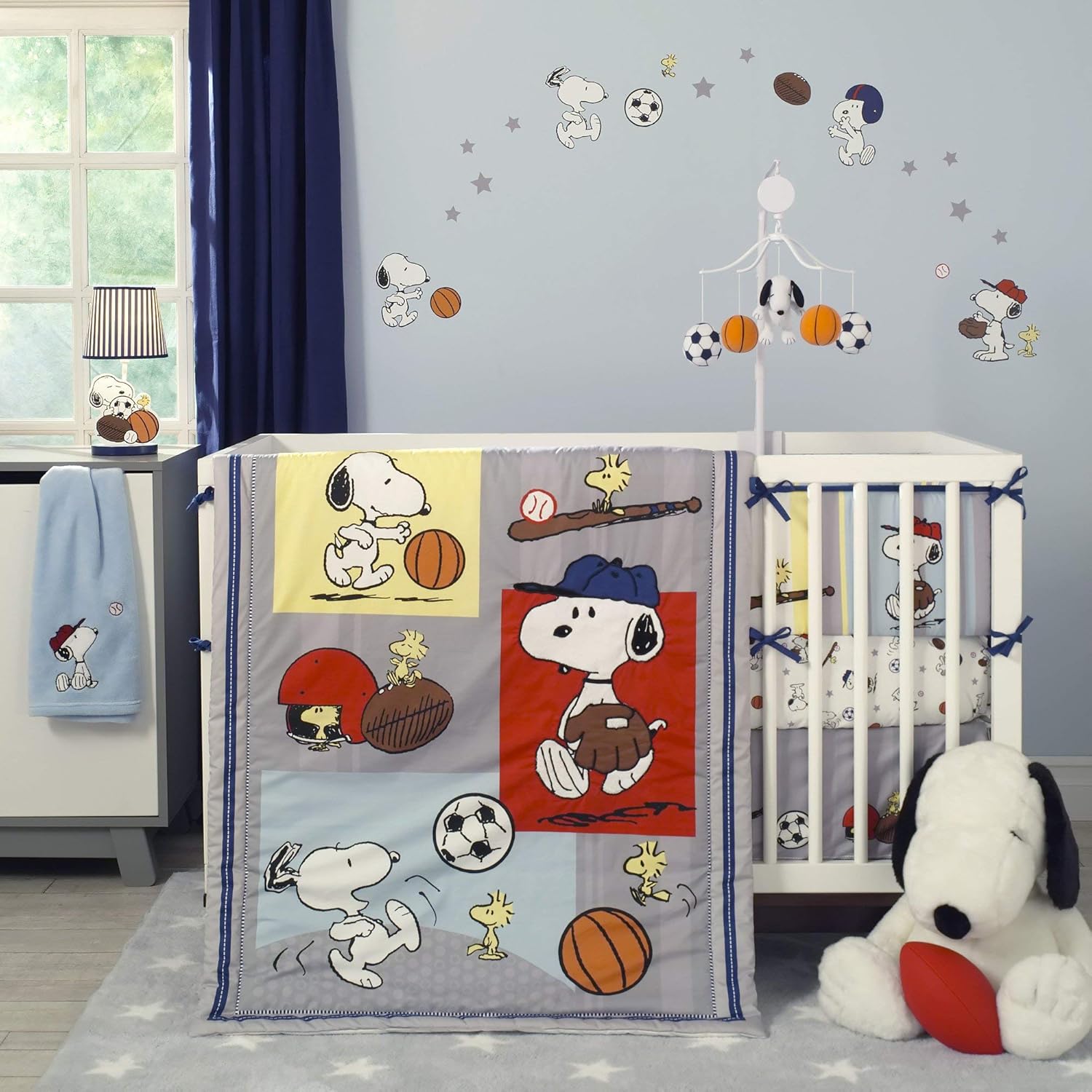 Lambs & Ivy Bedtime Originals Snoopy Sports Bedding Set front view featuring blue appliqued comforter