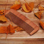 Eco friendly wooden comb held in hand for scale