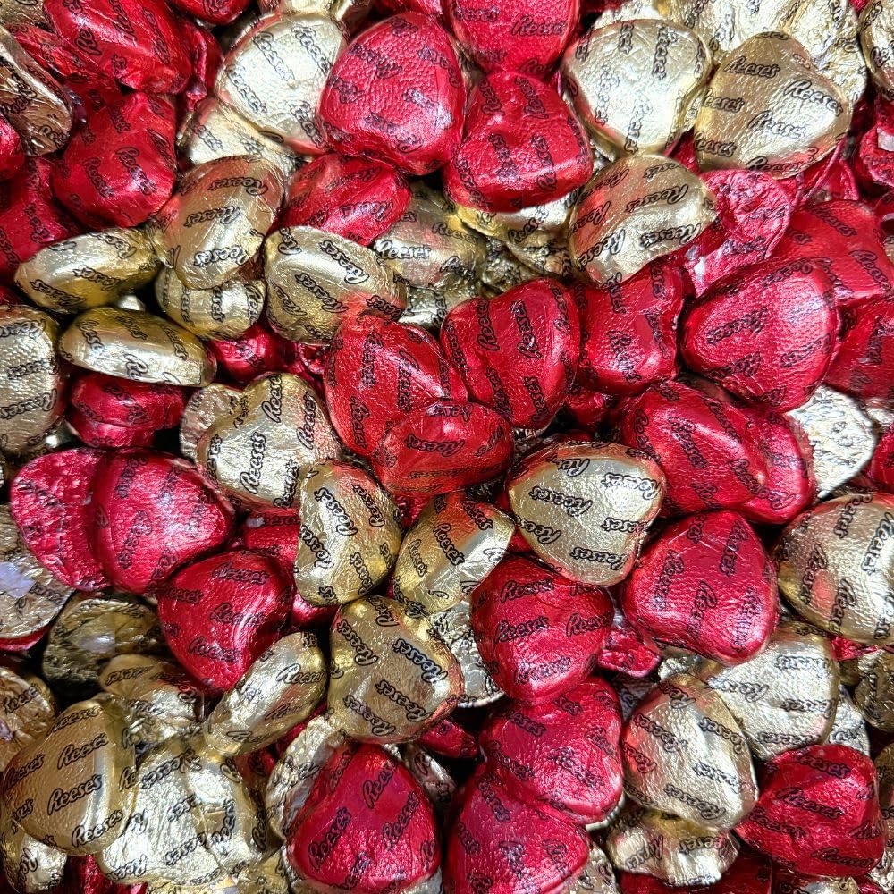 Individually wrapped red and gold foil chocolate peanut butter heart treats spread out