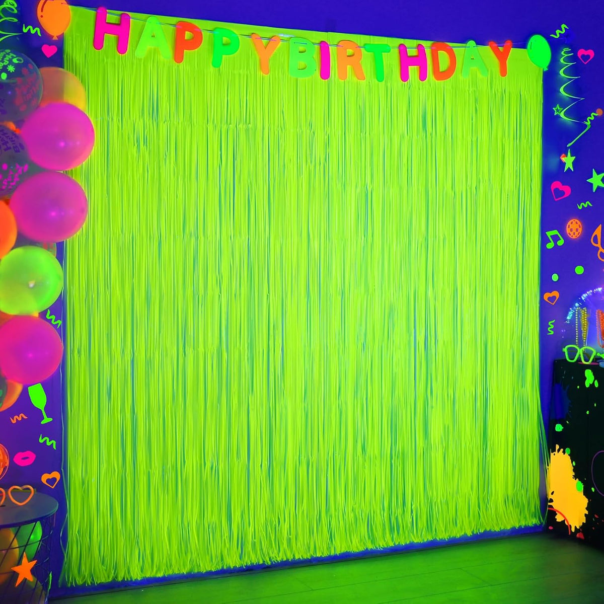 Mega-Loopolis glow in the dark party supplies front view showing two packs of fluorescent yellow tinsel curtains hanging on a wall