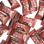 Hand holding a single Chimes cacao ginger chew showing its chewy texture