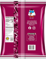 Individually wrapped raspberry Tootsie Pops spread out from the bulk fifty count packaging.