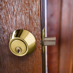 Design House polished brass deadbolt installed on door