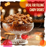 A pile of clear plastic wrapped old fashioned caramel cubes displayed on a neutral background.