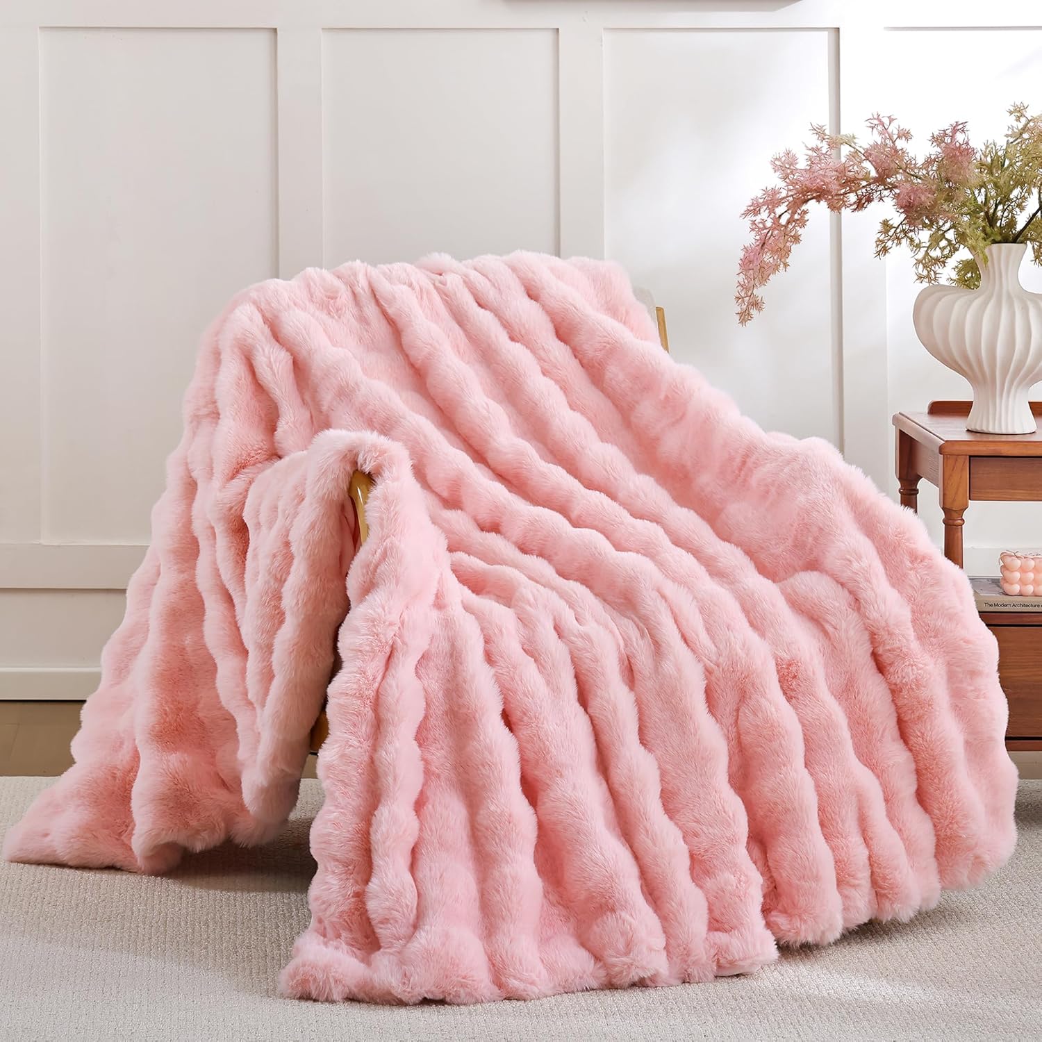 Smoofy blush pink faux fur throw blanket on a modern living room couch