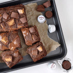 Justin's Nut Butter gluten-free dark chocolate minis next to a bowl of fresh peanuts