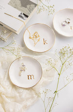 Close up of embossed gold monogram letter k on white ceramic
