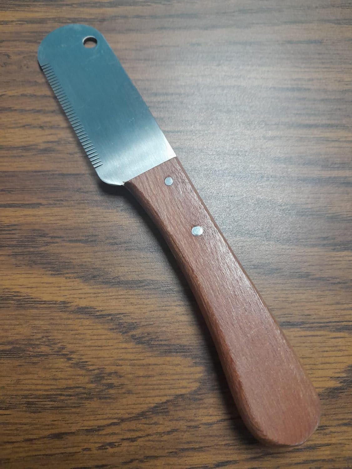 Tamsco medium teeth stripping knife held for pet grooming demonstration