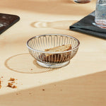 Alessi stainless steel wire basket styled on a modern dining table